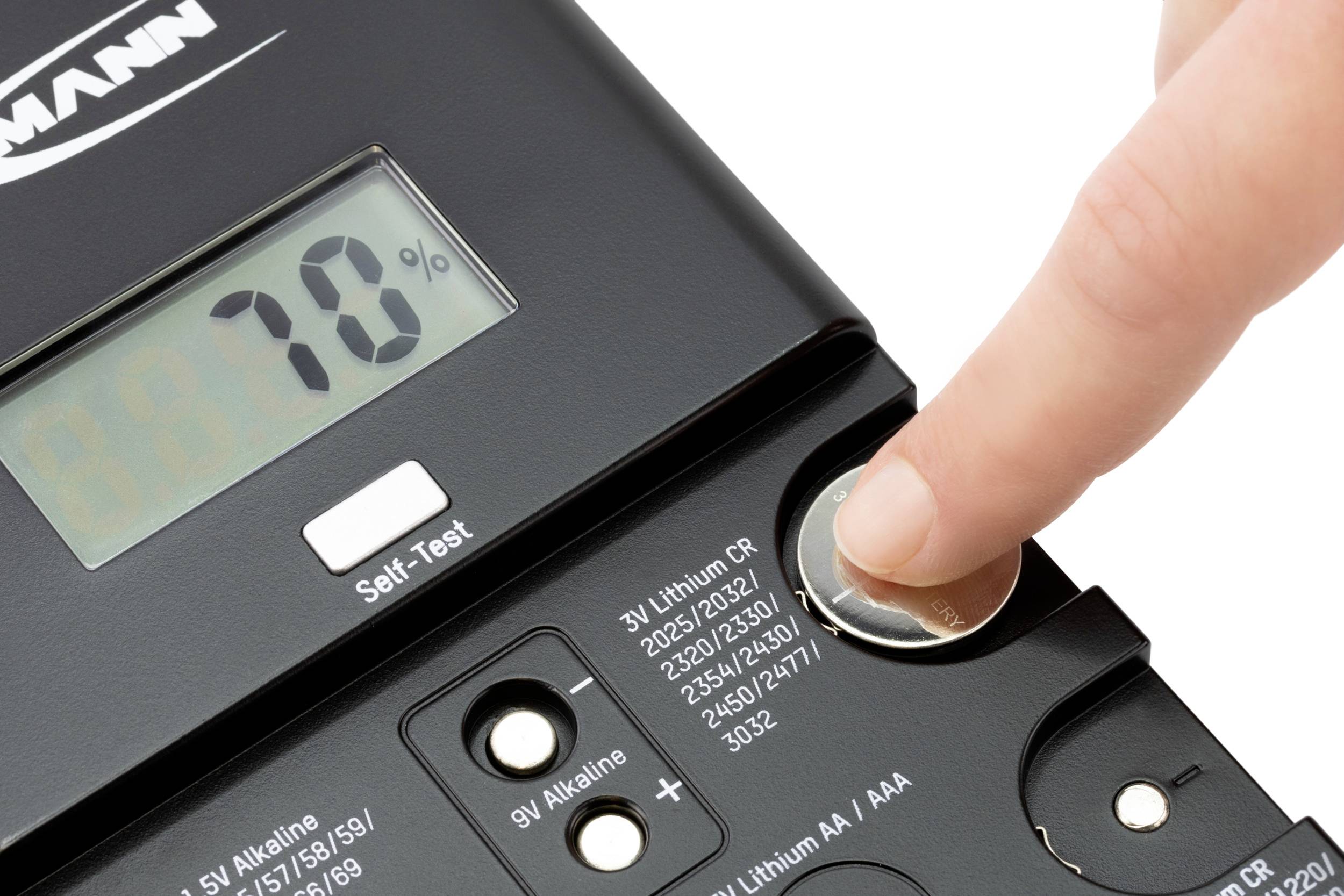 Een hand test de spanning van een batterij met een digitaal batterijtesters. Op het display staat '70%'.