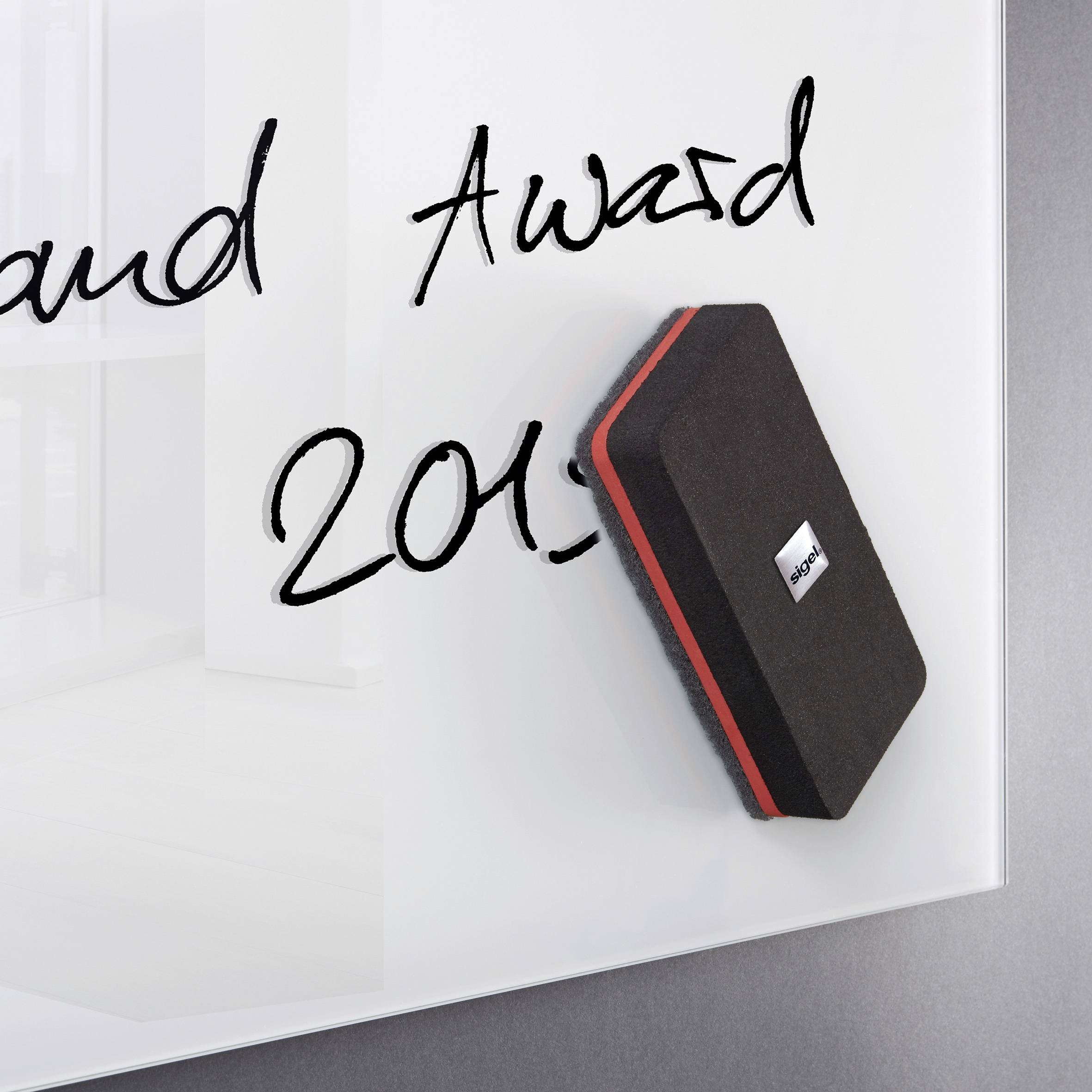 Een whiteboard met zwarte tekst 'Award 2015'. Een bordspons ligt ernaast.