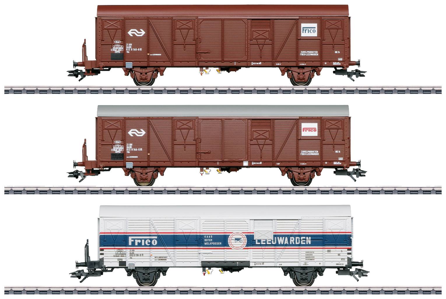 Drie goederenwagons op rails: twee bruine met 'NS'-logo en een witte met 'FRICO' en 'LEEUWARDEN' tekst, tonen verschillende ontwerpen.