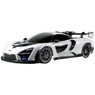 Een witte sportwagen met zwart dak en accenten, een aerodynamisch ontwerp en grote achterspoiler, staat op een grijze achtergrond.