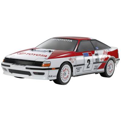 Een wit-rood racewagen in rallystijl met het nummer 2 en 'Toyota'-logo's. Het design doet denken aan klassieke motorsportvoertuigen.
