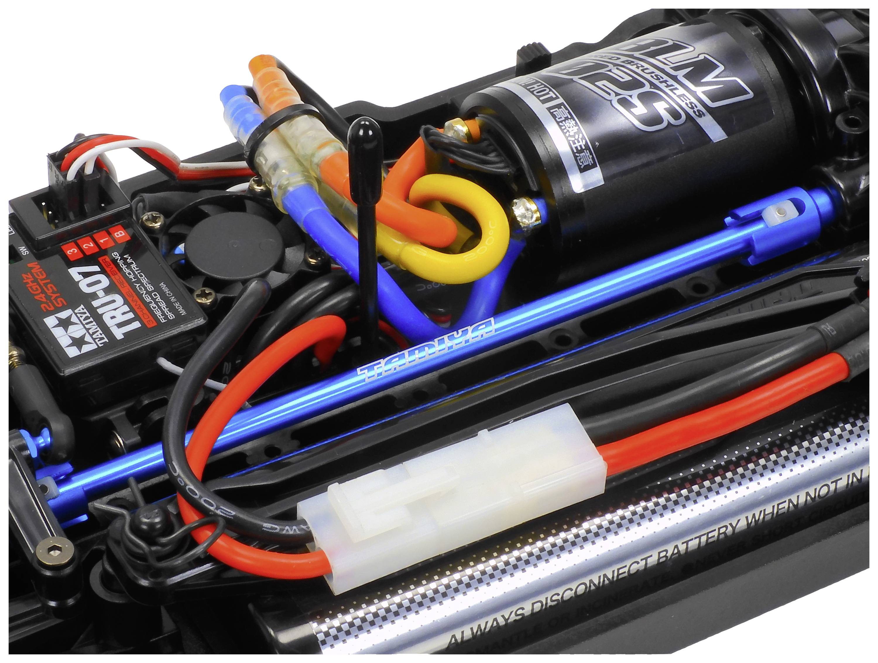 Close-up van een radiografisch bestuurbaar auto-chassis. De motor, kabels, ontvanger en een batterij zijn zichtbaar.