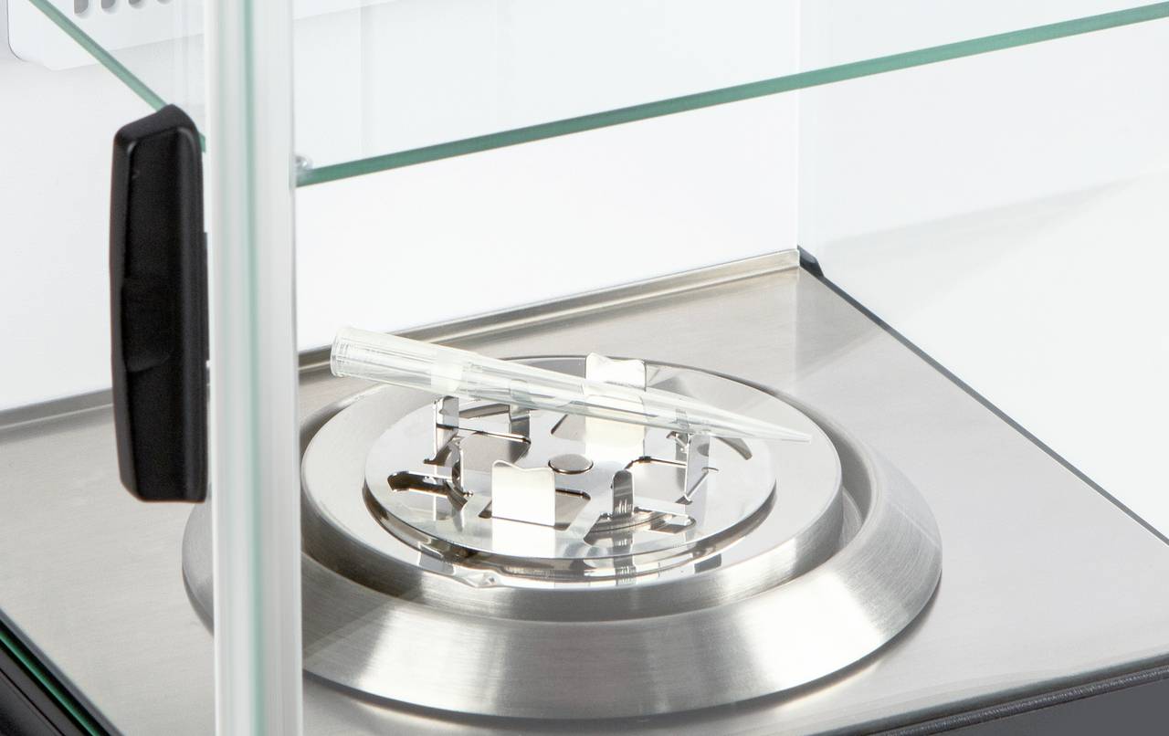 Een glazen vitrine met een binnenliggend laboratorium werkblad, waarop een reageerbuis rust op een metalen standaard.