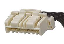 Een witte elektronische connector met meerdere aansluitingen en aangesloten zwarte kabels.