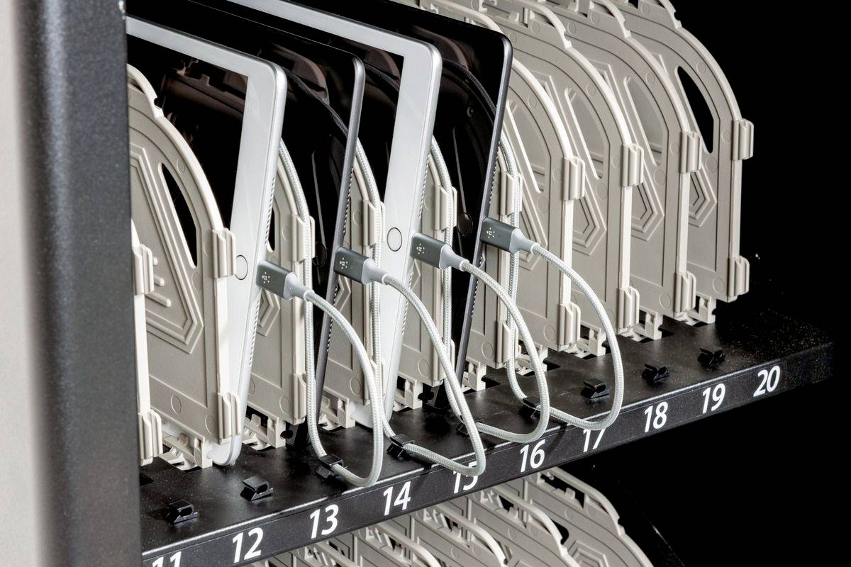 Tablet-opslagsysteem met genummerde sleuven. Meerdere tablets zijn veilig aangesloten met kabels en geplaatst in de sleuven.