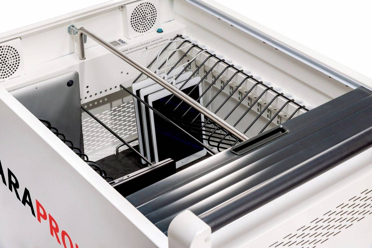 Binnenaanzicht van een industriële wasmachine met metalen rekken en slangen, klaar om voorwerpen te reinigen.