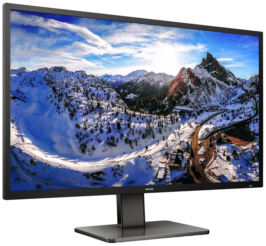 Een monitor toont een berglandschapsafbeelding met met sneeuw bedekte toppen en een heldere blauwe lucht.