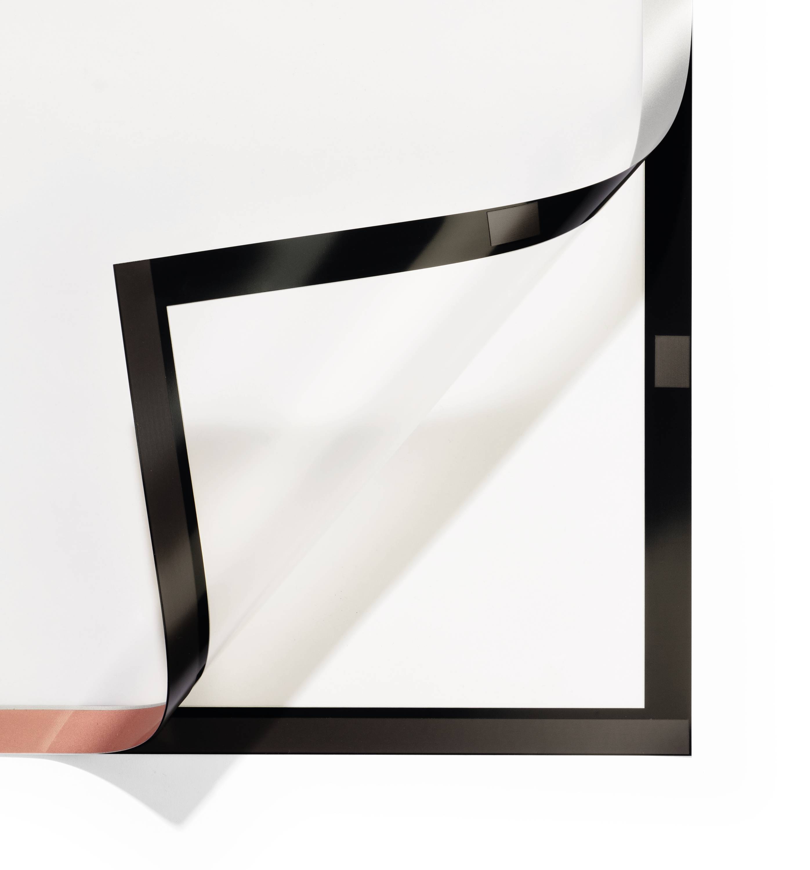 Een wit vel papier wordt diagonaal van de rechterbovenhoek naar beneden gevouwen en onthult een zwarte achterkant.