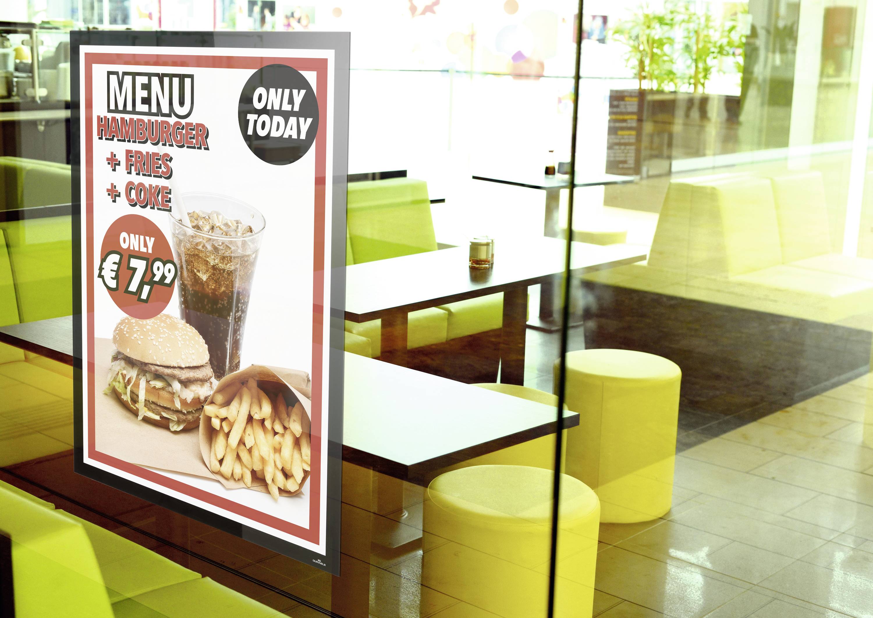 Een reclameposter in het restaurantraam biedt 'Hamburger + Friet + Cola' aan voor 7,99 EUR. Aanbieding is alleen vandaag geldig.