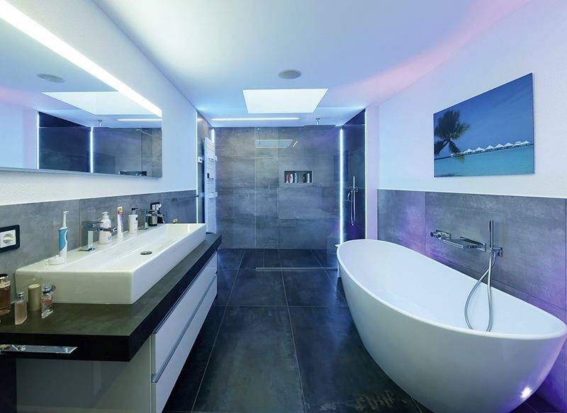 Modern badkamer met vrijstaand bad, groot wastafelmeubel en verlichte spiegel. Strakke, elegante inrichting.
