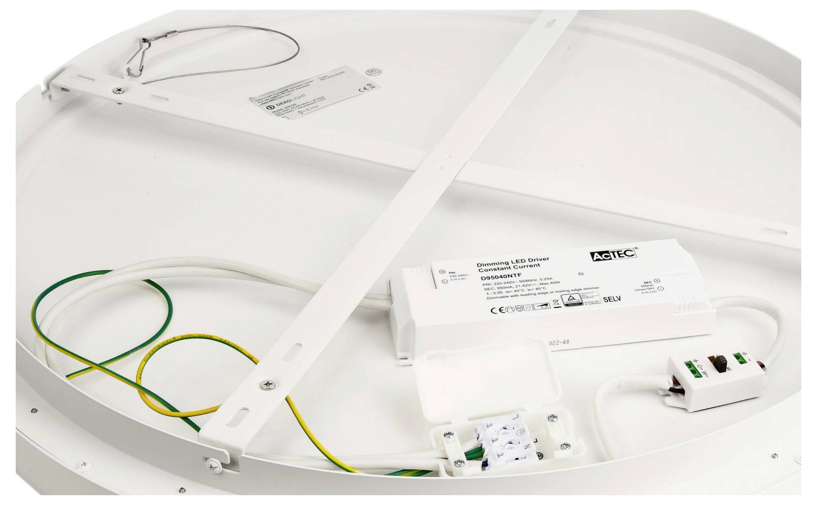 Achterkant van een ronde LED-lichtpaneel met montagebeugels, bedrading en een driver-/regelmodule die aan de armatuur is bevestigd.