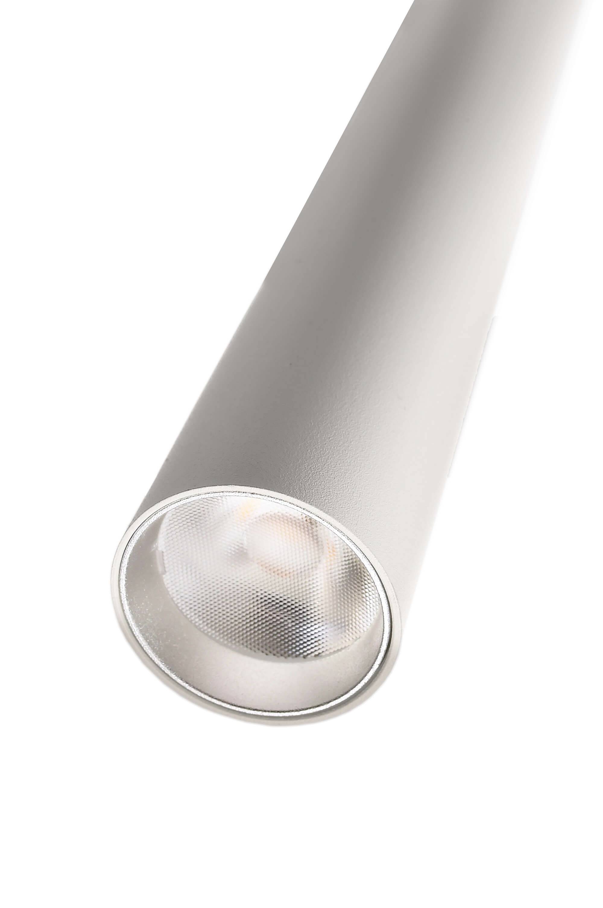 Een cilindrische zilveren spotlamp is schuin van opzij te zien, met het verlichtingselement binnenin licht zichtbaar.