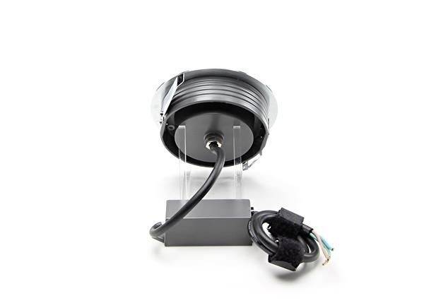 Een zwarte kabeloproller met kabel, gemonteerd op een transparante houder, naast een aansluitdoos en losse kabeluiteinden.
