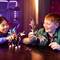 Twee kinderen zitten aan een tafel en spelen lachend met kleurrijke speelfiguren en een paard. De scène is kleurrijk verlicht.