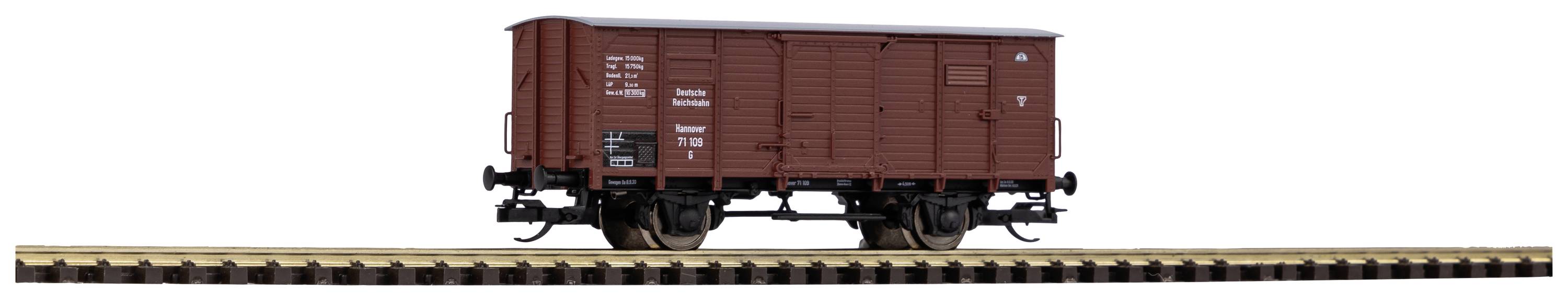 Een bruine goederenwagon op een spoor met opschriften aan de zijkant. De wagon staat stil en toont basale details.
