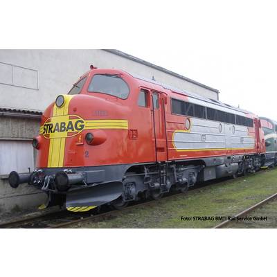 Een rode diesellocomotief met het opschrift 'STRABAG' staat op een rangeerterrein. De locomotief heeft gele en zilveren strepen.