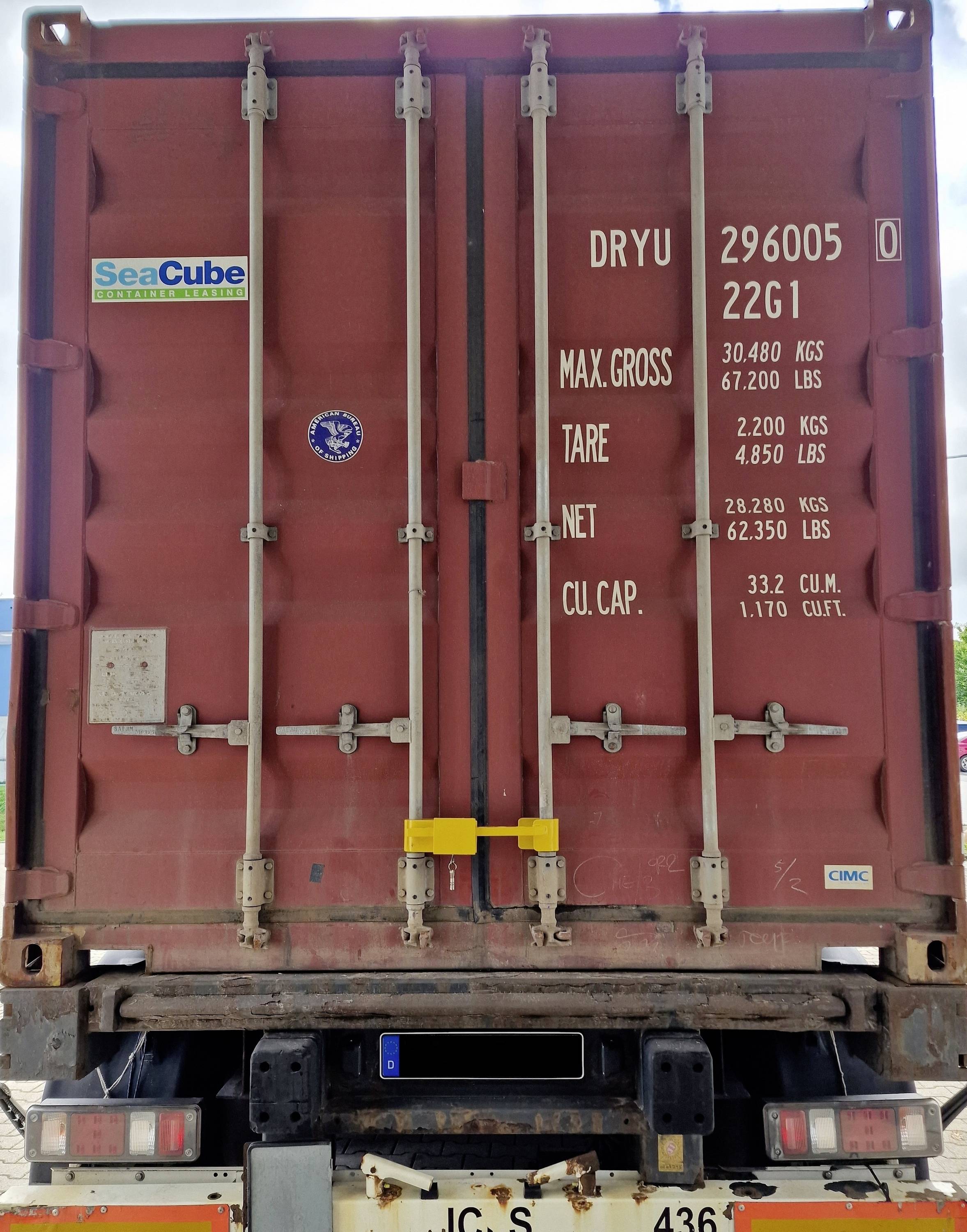 Een rode containerdeuren met teksten over gewichtsgegevens: MAX.GROSS 30.480 KGS, TARE 2.220 KGS, NET 28.260 KGS, CU.CAP. 33.2 CUM.