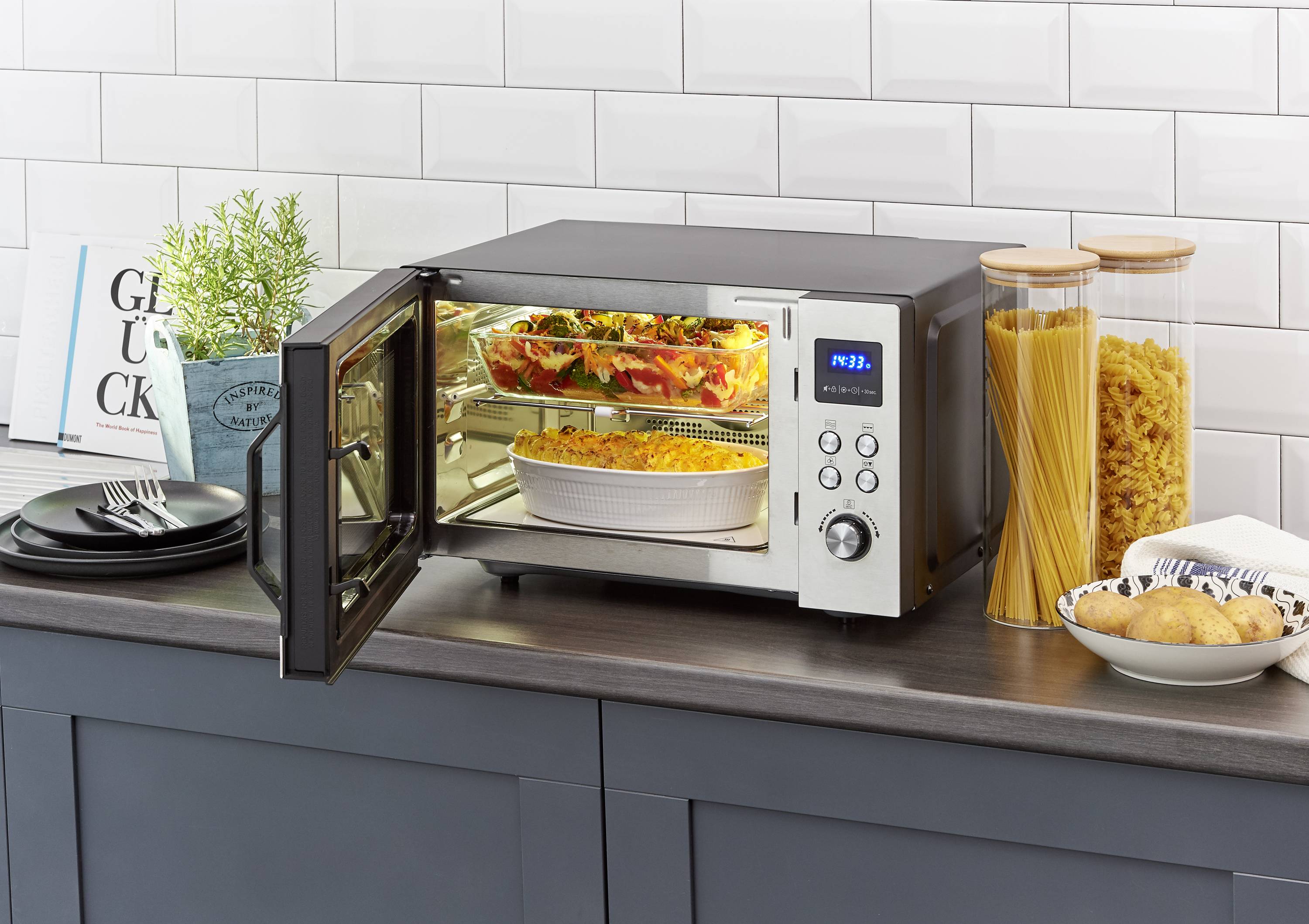 Een oven met glazen front toont daarin twee boven elkaar gestapelde ovenschalen met gebakken, goudbruin gegratineerd gerecht.