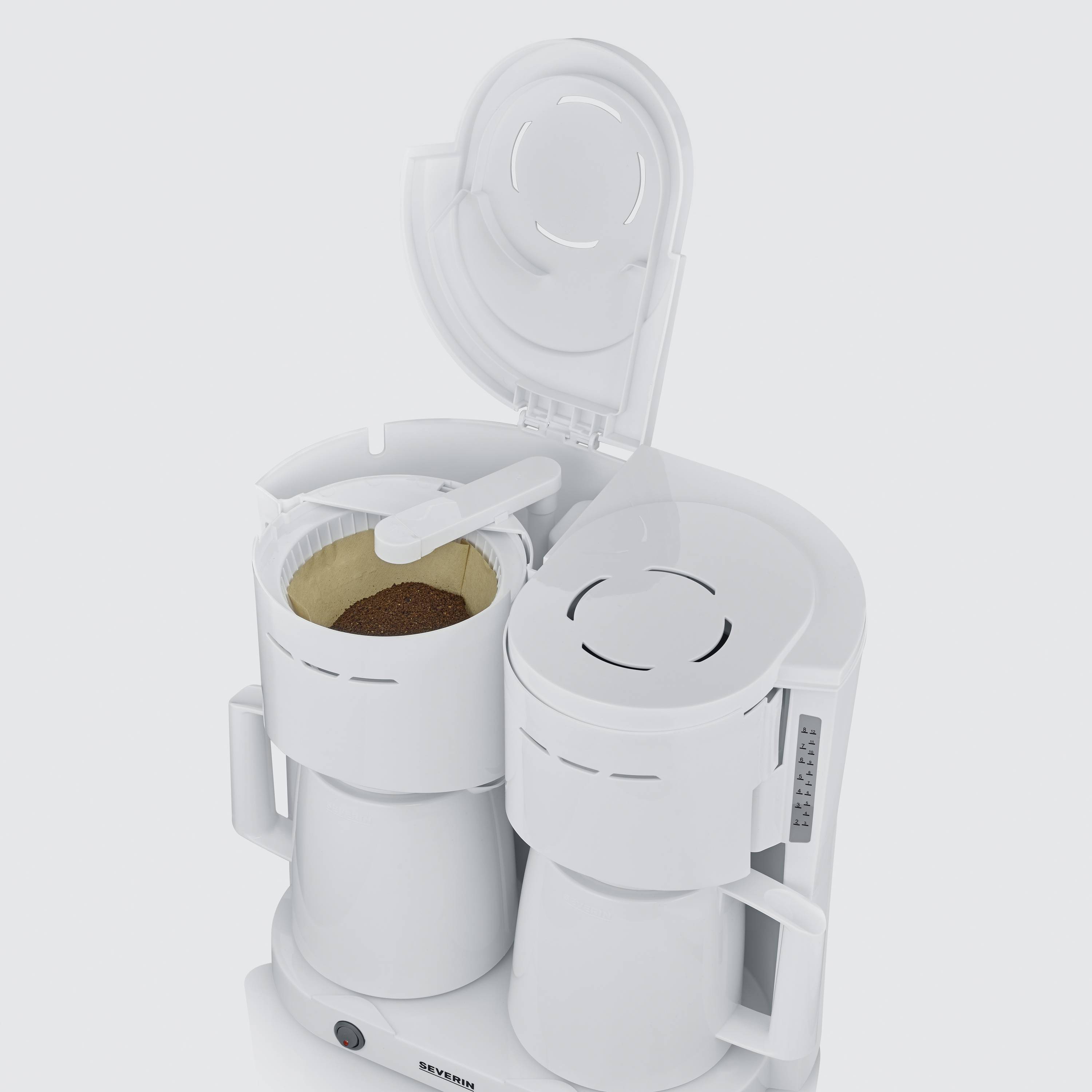 Een geopende witte koffiemachine met een gevulde koffiefilter, klaar om te zetten.