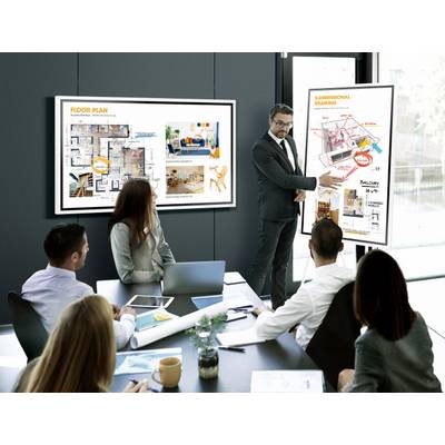 Een zakenman presenteert gebouwdiagrammen en plattegronden op twee schermen tijdens een vergadering met vier collega's.