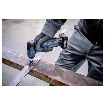 Een gehandschoende werker gebruikt een draadloze Bosch haakse slijper om verroest metaal op een stalen balk glad te slijpen.