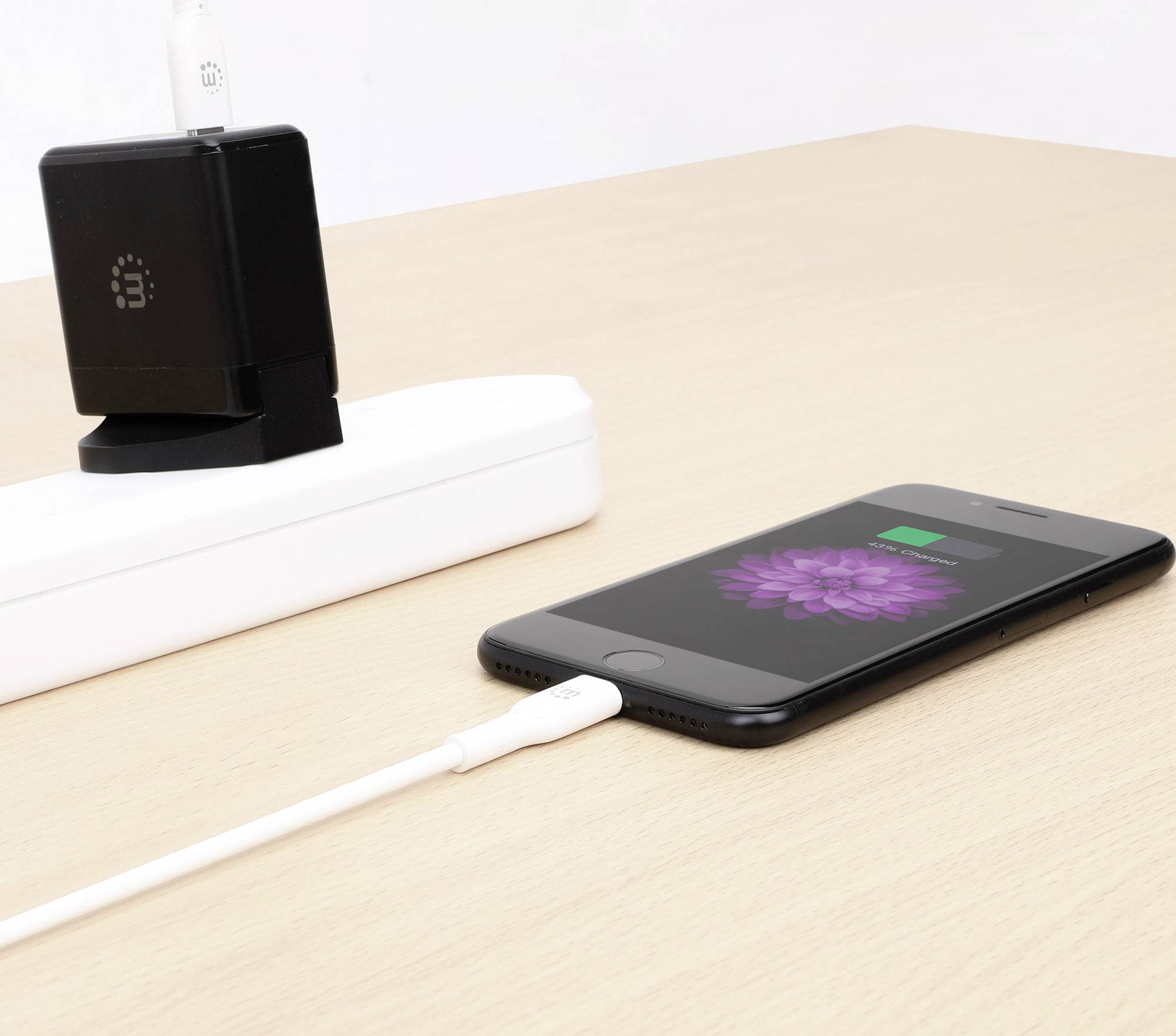 Smartphone wordt opgeladen op tafel met een USB-kabel, aangesloten op een stekkerdoos. Laadstatus is zichtbaar op het scherm.