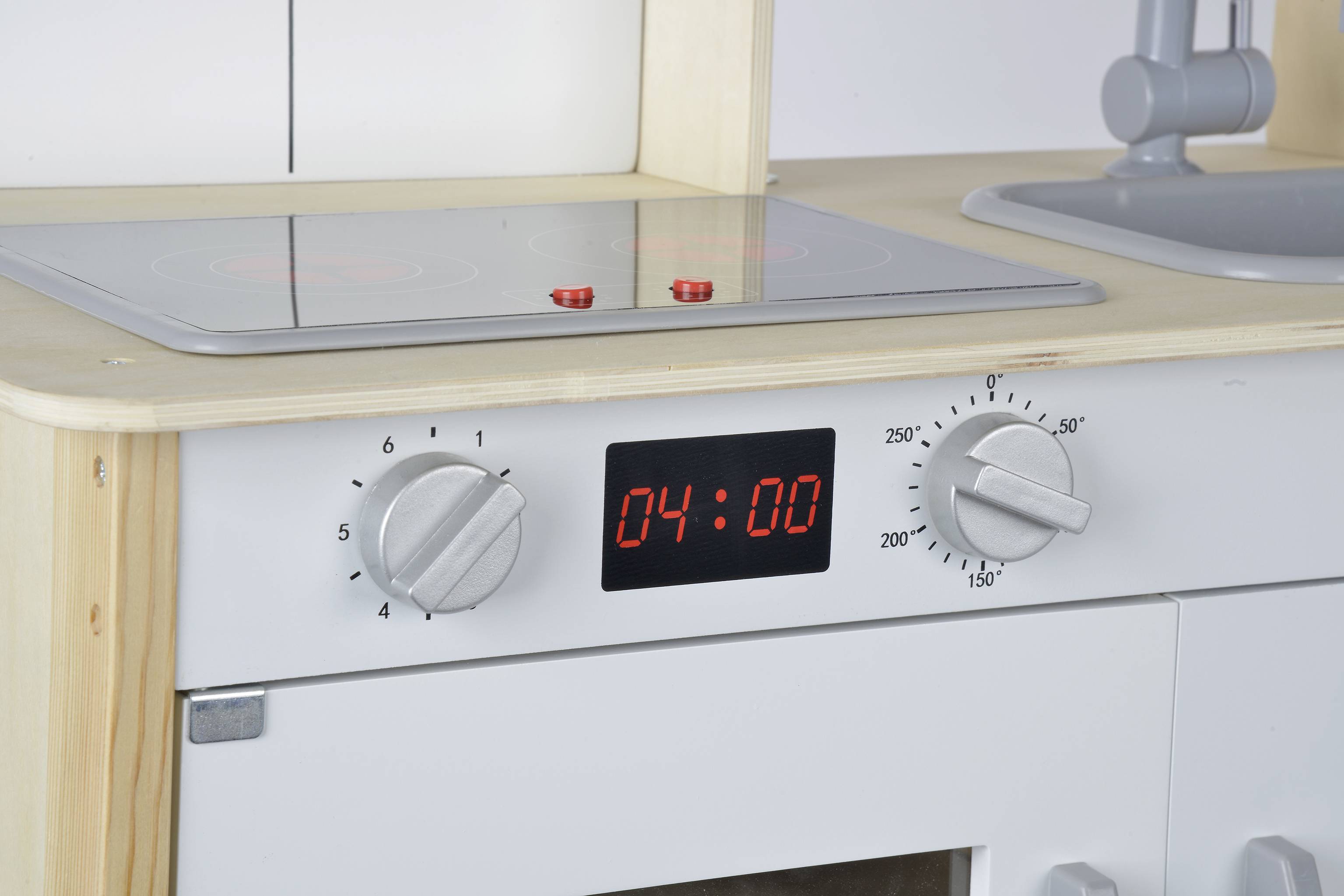Speelgoedkeuken met fornuis en gootsteen, toont de tijd '04:00' op een digitaal display. Twee kookplaatknoppen zijn ingesteld op niveau 6.