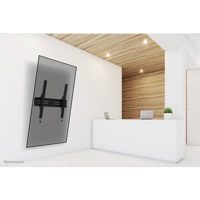 Een moderne receptieruimte met een witte balie, twee laptops en een schuin aan de muur gemonteerde displayhouder.