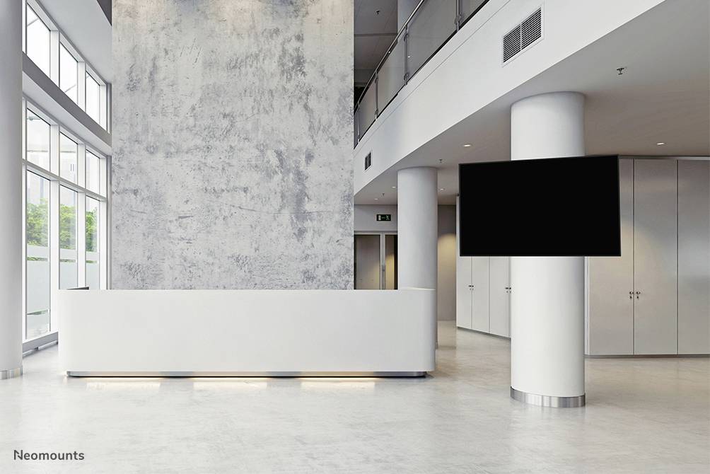 Verlichte receptiebalie in een moderne, minimalistische lobby met een leeg scherm op een grote zuil, in neutrale kleurstelling.