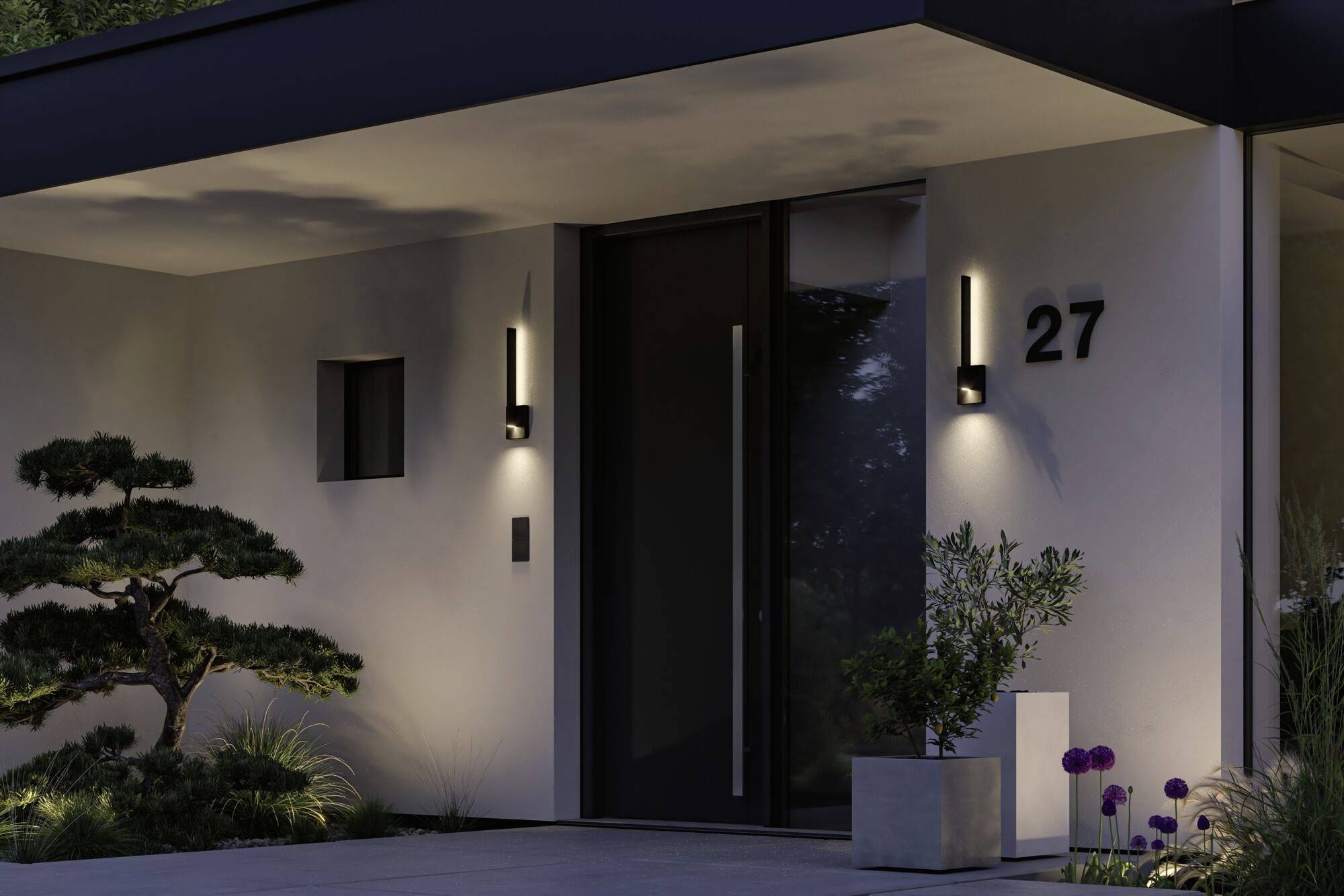 Voorgevel met moderne voordeur, huisnummer 27. Verlichting en goed onderhouden planten accentueren de entree.