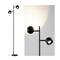 Staande lamp met twee zwarte spots in modern design. Links de hele lamp, rechts close-up van een ingeschakelde spot.