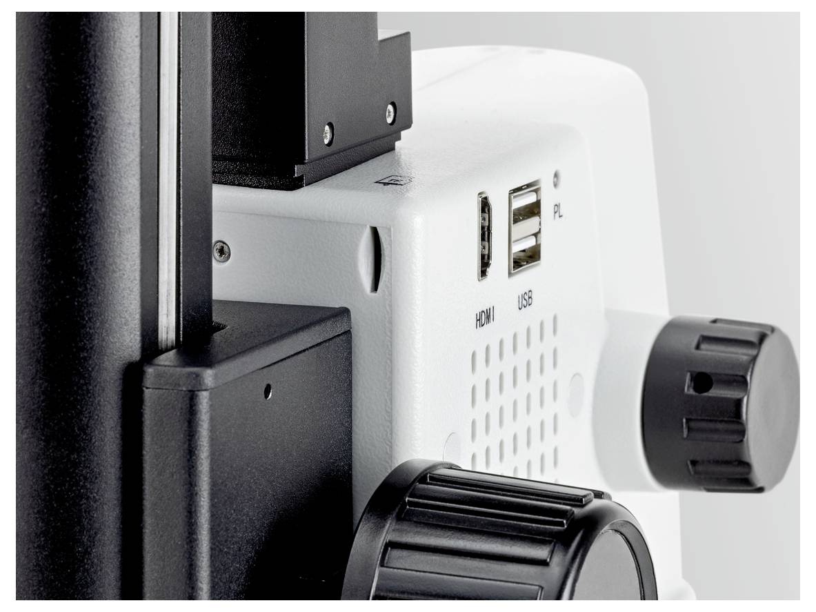 Een microscoop-aansluiting met twee USB-poorten en een HDMI-aansluiting, een zwart focuswieltje en een wit behuizing.