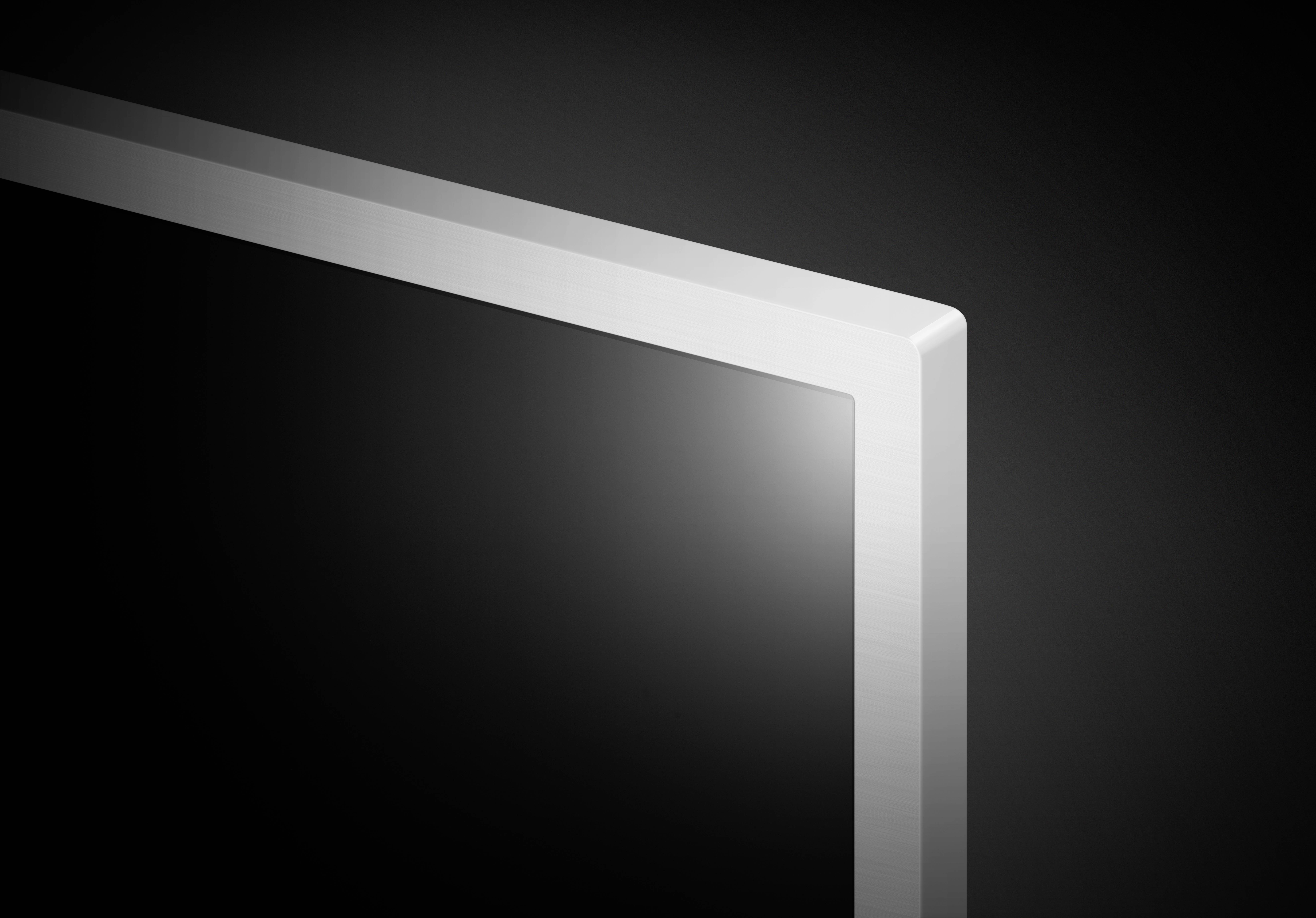 Hoek van een modern flatscreen-scherm tegen een zwarte achtergrond. Minimalistisch ontwerp, metallic lijst, elegant en sober.