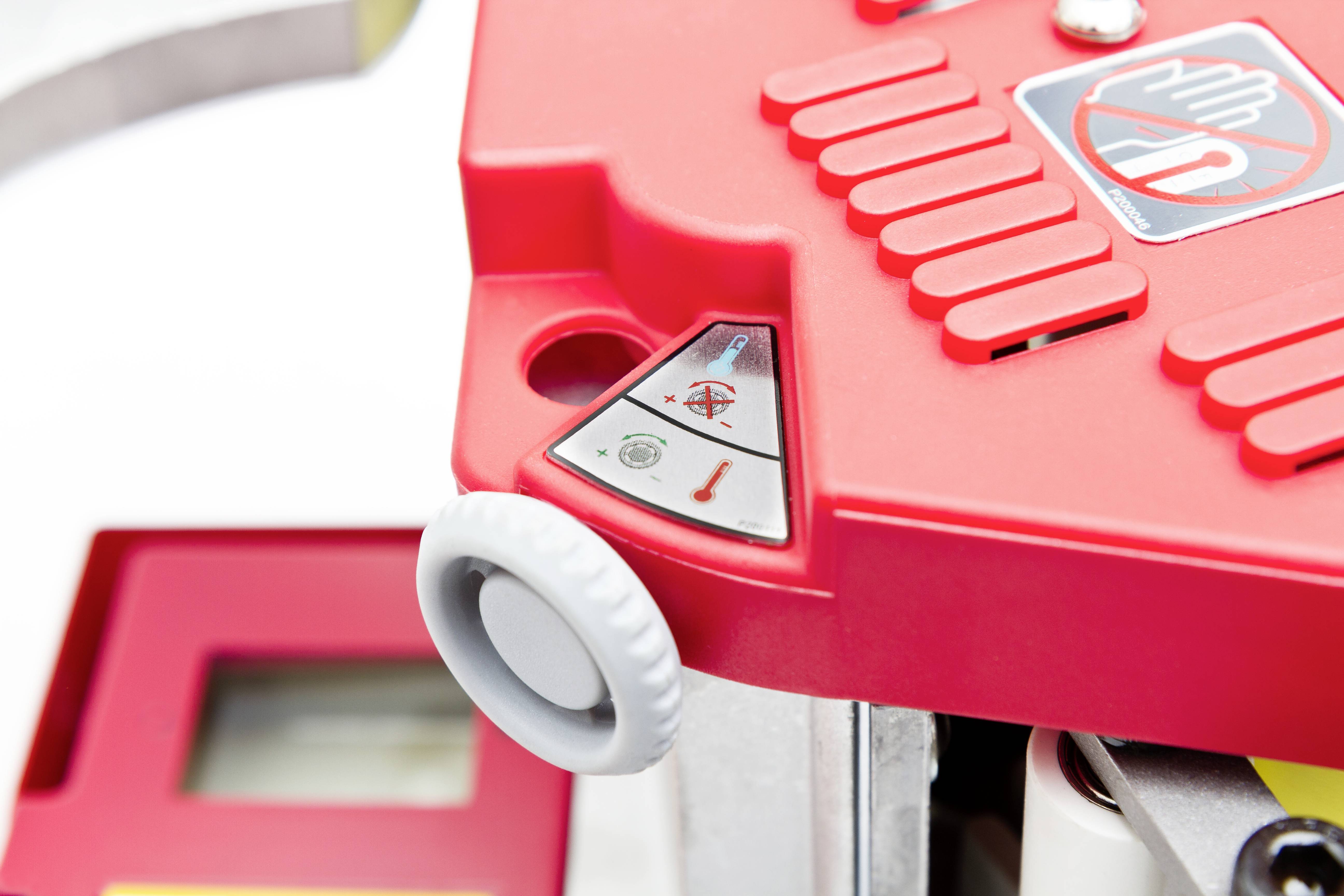 Rode machine met veiligheidswaarschuwingssymbolen en hendel, toont waarschuwing voor gevaar bij aanraking. Belangrijkste kenmerk is een witte draaiknop.