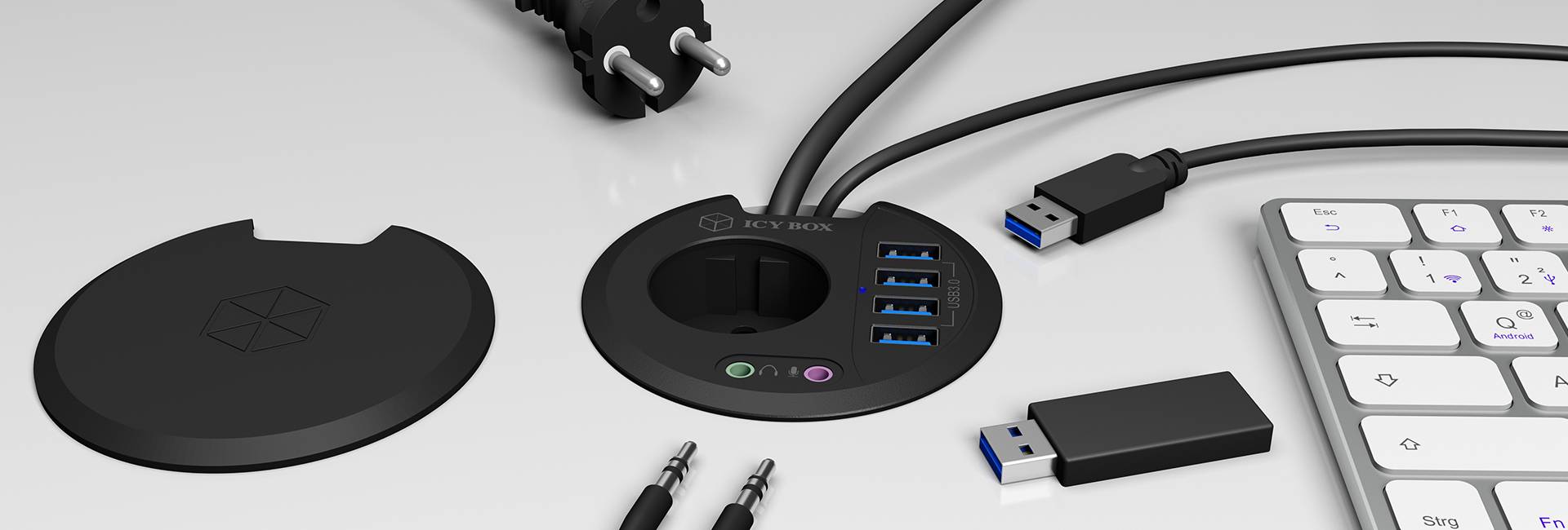 Een USB-hub met vier USB-poorten, twee audioaansluitingen, kabels en een beschermkap ligt naast een externe toetsenbord en een USB-stick.