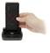Een hand houdt een zwarte smartphone met een rood X-patroon boven een zwart oplaadstation. De smartphone toont de achterkant.