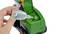 Een hand vult met een pipet vloeistof in een groene speelgoedtractor.