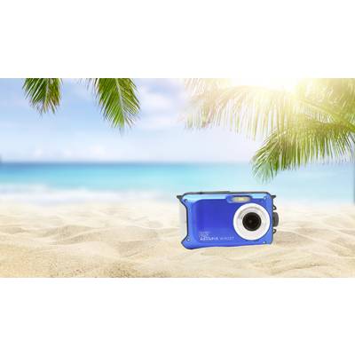 Blauwe camera ligt op een zonnig zandstrand met palmbomen en een blauwe zee op de achtergrond.