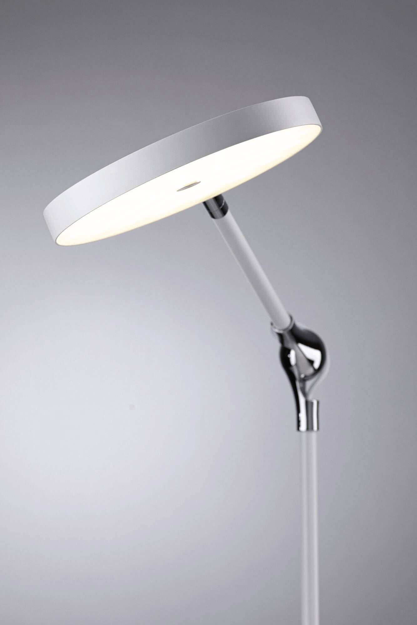 Moderne vloerlamp met een ronde, witte lampenkap, gericht op de leeshoek. Elegant design in minimalistische stijl.