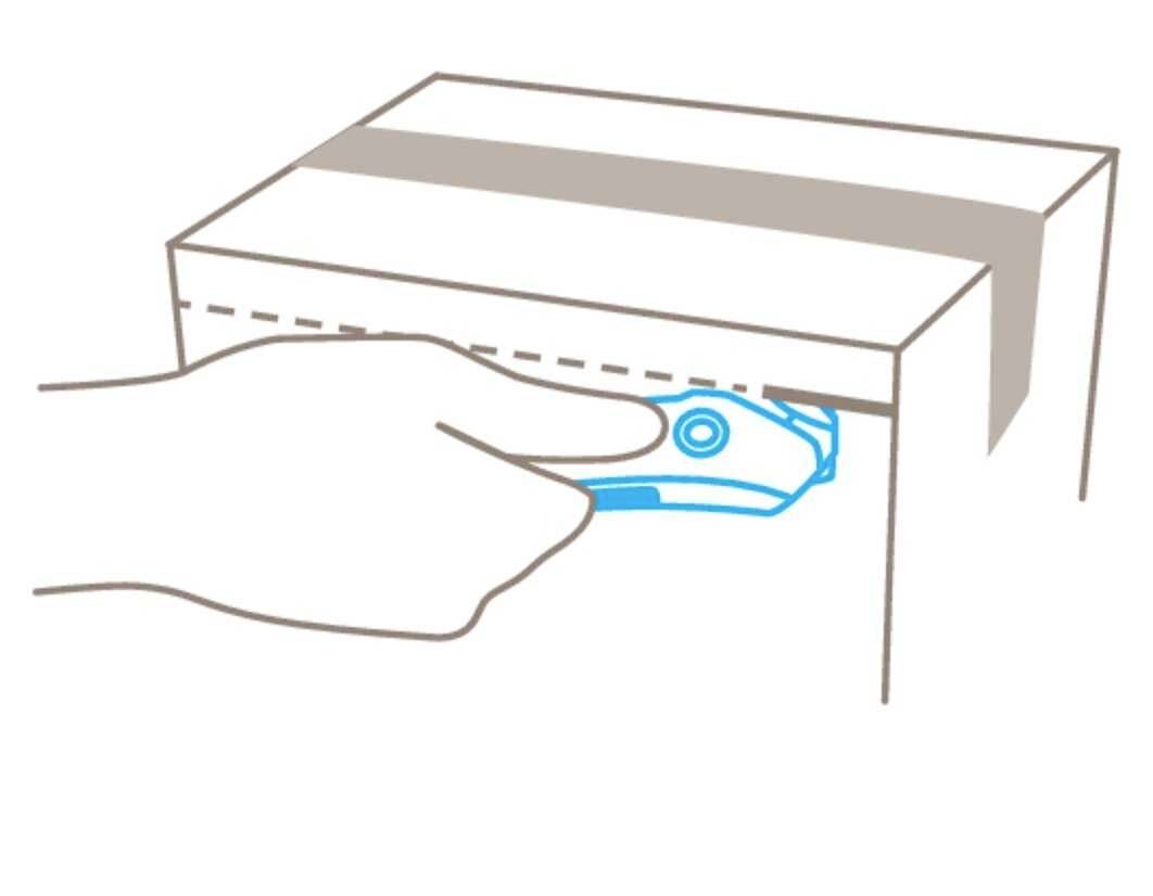 Een hand gebruikt een stanleymes om het plakband op een kartonnen doos te openen.