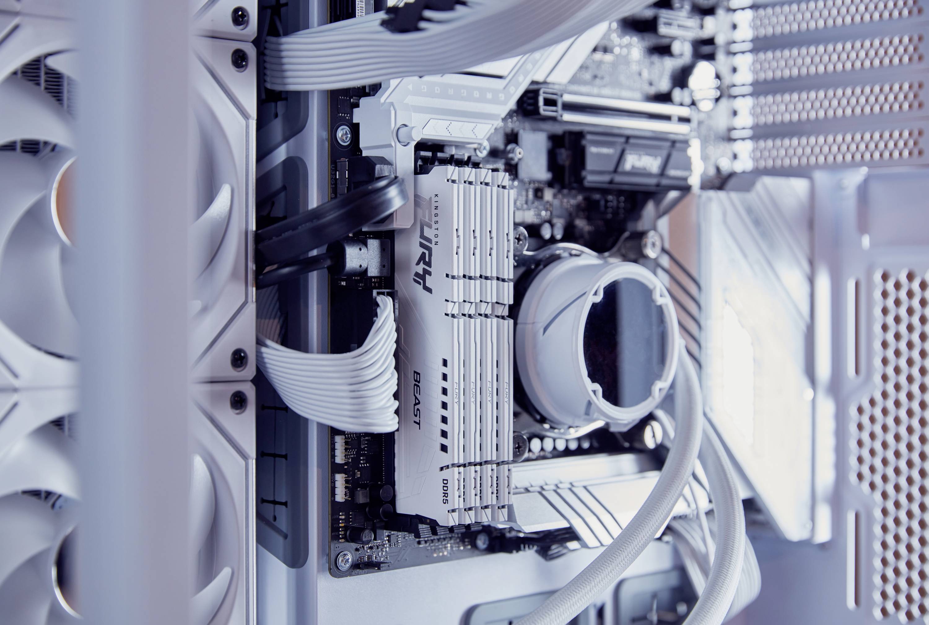 Computerbinnenkant: Moederbord met RAM-modules, kabels en koelcomponenten in een goed georganiseerde behuizing.