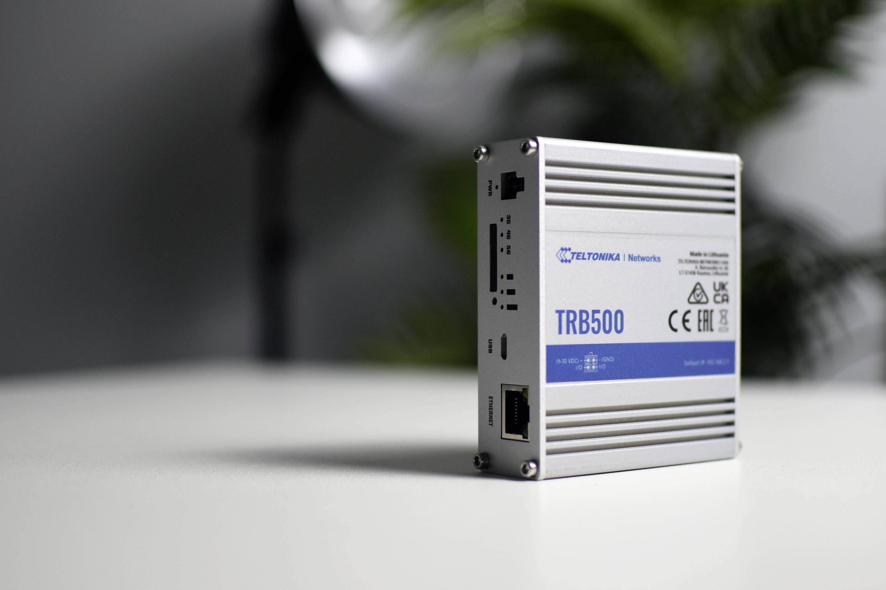 Industriële router 'TRB500' op een tafel, gebruikt voor netwerkoplossingen. Apparaat heeft aansluitingen zichtbaar aan de linkerkant.