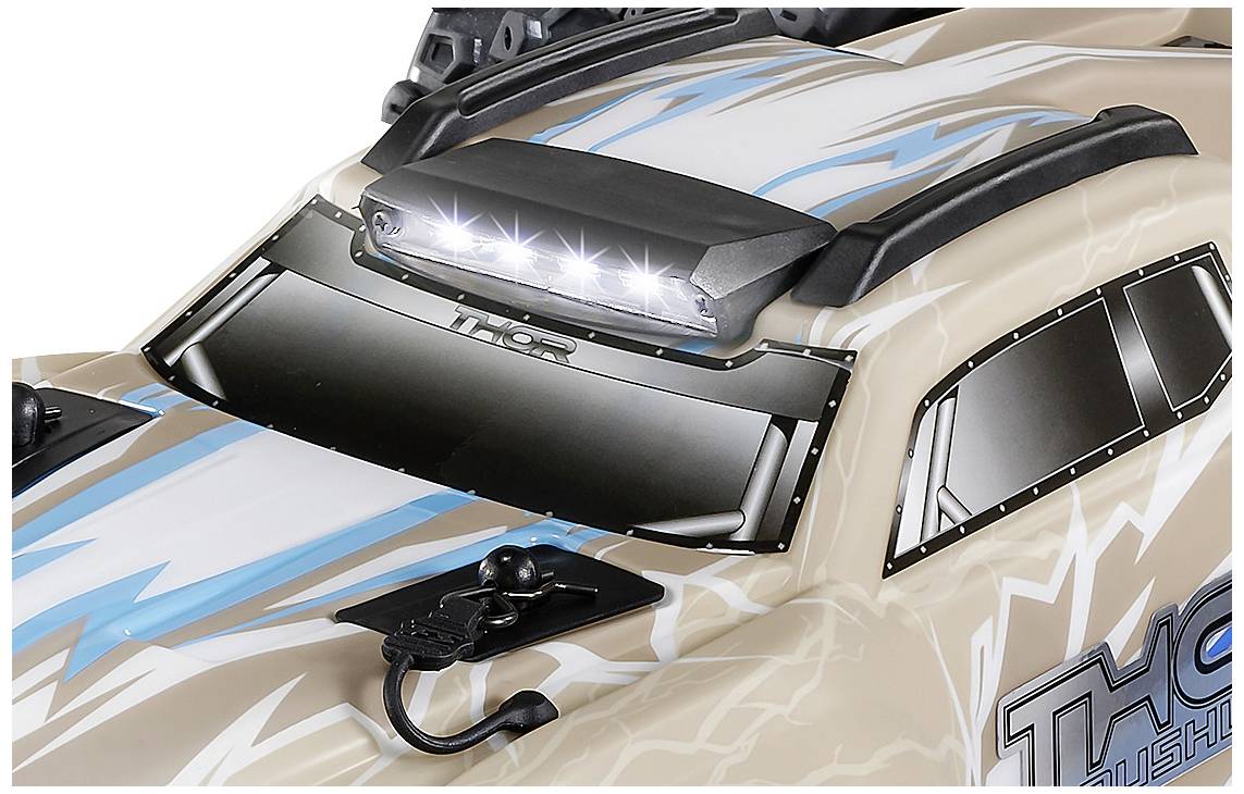 Close-up van een speelgoedauto met flitsend LED-licht op het dak, beige carrosserie en blauwe flitsontwerpen.