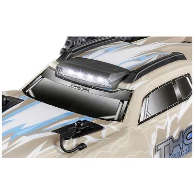 Close-up van een speelgoedauto met flitsend LED-licht op het dak, beige carrosserie en blauwe flitsontwerpen.