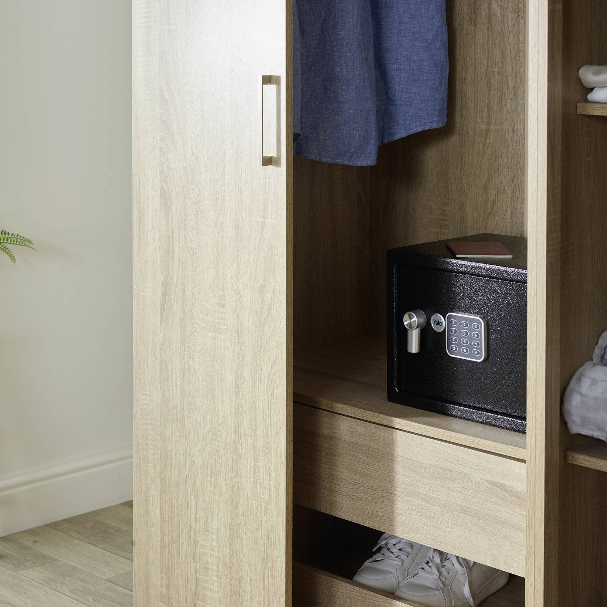 Een open houten kast toont een digitale kluis op een plank. Eronder staat een paar witte sneakers.