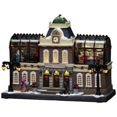 Een miniatuurmodel van een treinstation genaamd 'Union Station' met feestelijke decoraties, verlichte lantaarns en figuurtjes van binnen.
