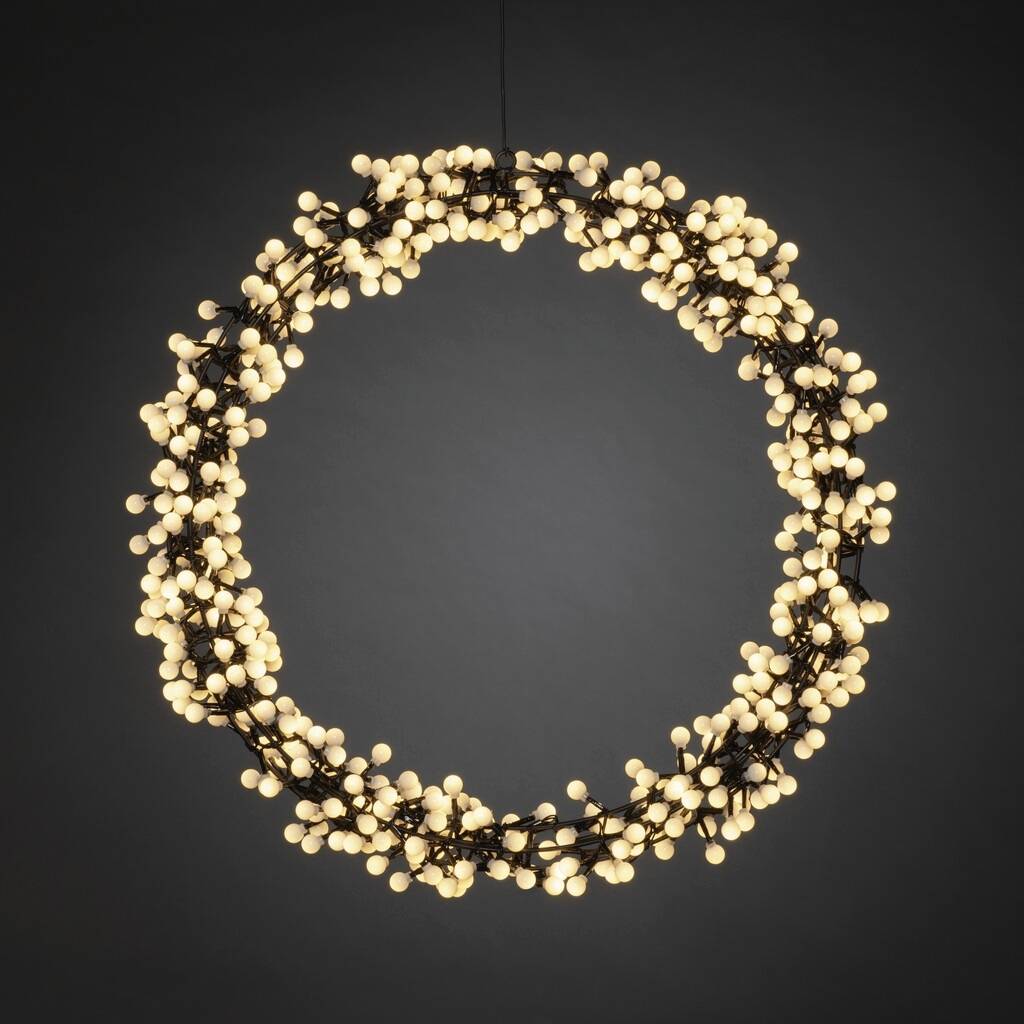Een ronde kroonluchter, bestaande uit vele kleine, lichtgevende bollen, hangt aan een donker plafond en straalt warm licht uit.