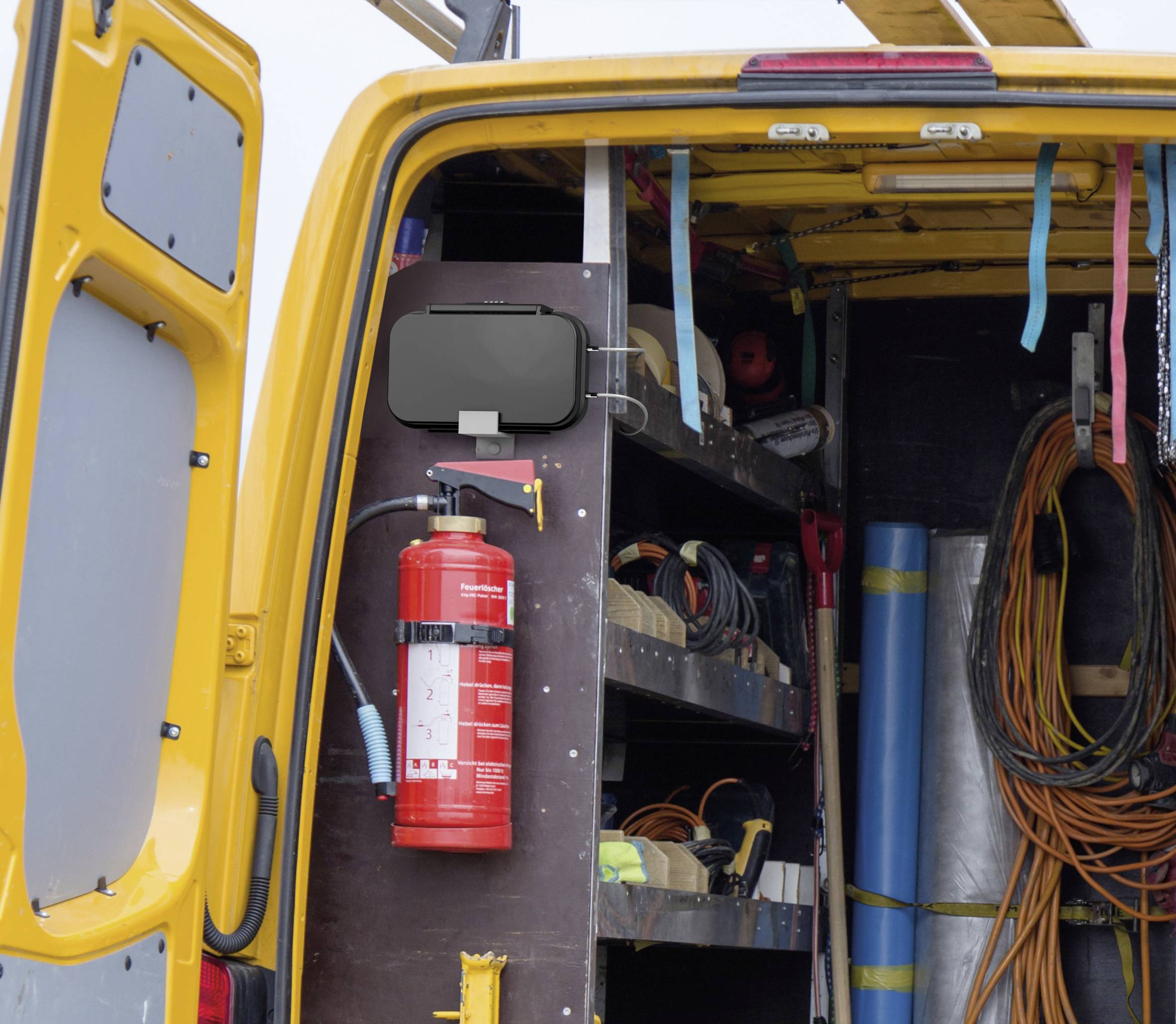 Gele bestelwagen met open laadruimte toont gereedschappen en materialen aan de binnenkant. Een brandblusser is prominent bevestigd.