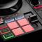 Verlichte pads en knoppen van een DJ-mixer voor het bedienen van beats, tempo en effecten.