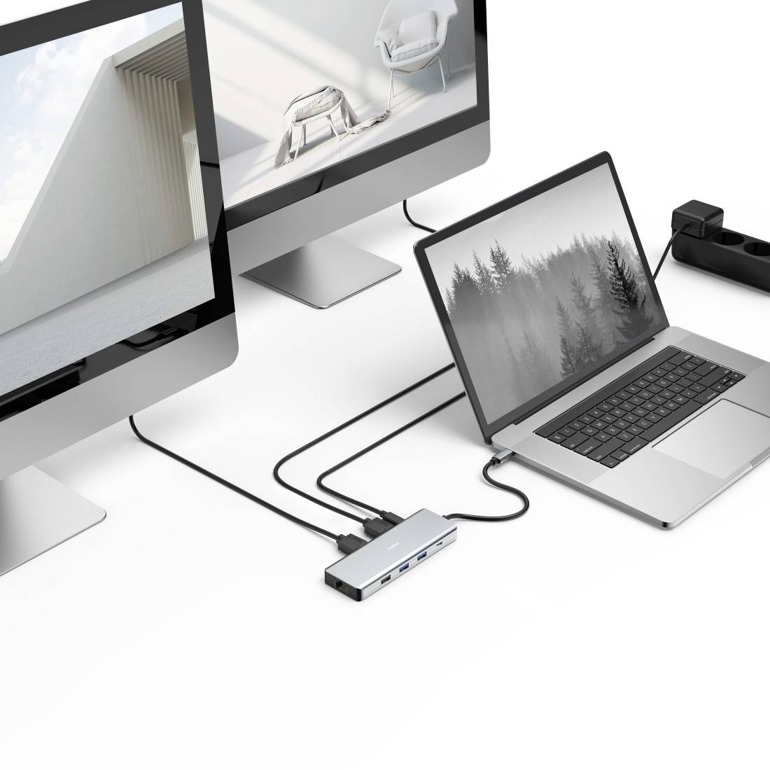 Een laptop is via een dockingstation-hub verbonden met twee grote monitoren die verschillende beelden weergeven.